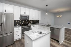 Rochester apartment for rent - a kitchen with white cabinets and stainless steel appliances