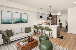 Kirkland apartment for rent - A modern living room with a white sofa, a coffee table, and a kitchen area in the background.