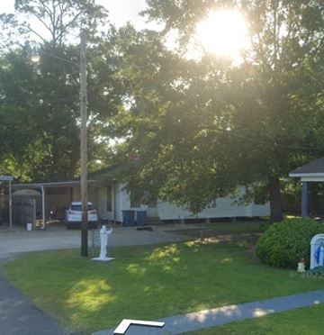 Lafayette house for rent - a yard with a white statue in front of a house