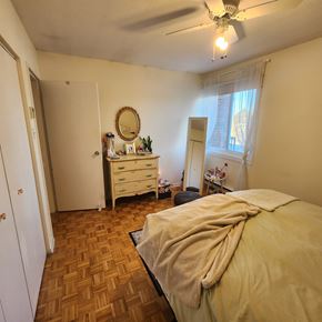 Ottawa apartment for rent - A bedroom with a bed, dresser, mirror, and window.