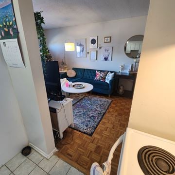 Ottawa apartment for rent - A living room with a blue couch and a white table.