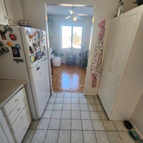 Ottawa apartment for rent - A kitchen with a white refrigerator covered in magnets and a white door.