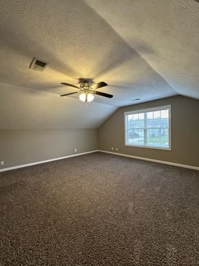 Clarksville house for rent - an empty bedroom with a ceiling fan and a window