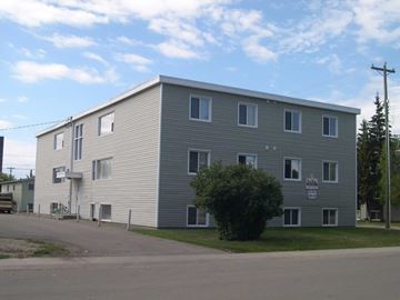 Grande Prairie apartment for rent - A grey building with a sign on the front.