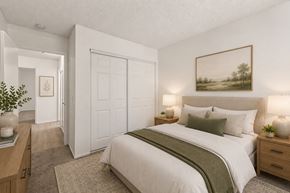 Cypress apartment for rent - A bedroom with a large bed, a painting on the wall, and a door.