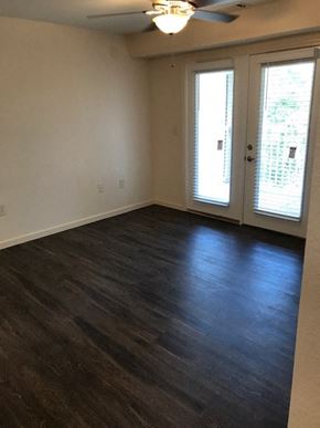 Blairsville apartment for rent - an empty living room with a wood floor and doors