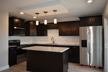 Clarksville house for rent - A modern kitchen with dark brown cabinets and a central island.
