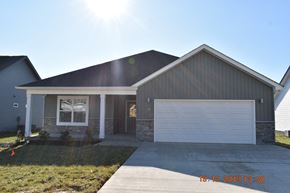 Clarksville house for rent - A house with a garage door and a window is shown on a sunny day.