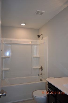 Clarksville house for rent - A white bathroom with a toilet, sink, and bathtub.