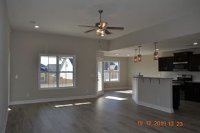 Clarksville house for rent - A spacious room with a ceiling fan and wooden flooring.