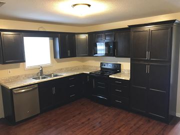 Clarksville house for rent - A kitchen with black cabinets and a white sink.