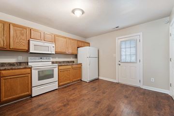 Jacksonville house for rent - a kitchen with white appliances and wooden cabinets