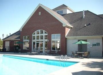 West Chester apartment for rent - a swimming pool in front of a brick building