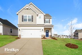 Greenville house for rent - a white house with a white garage door and a green lawn