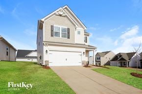 Greenville house for rent - a white house with a driveway in front of a lawn