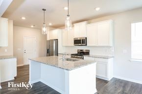 Greenville house for rent - a kitchen with white cabinets and a marble counter top