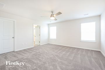Greenville house for rent - a spacious living room with carpet and a ceiling fan