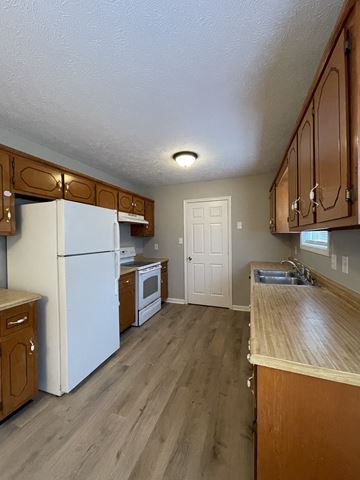 Oak Grove house for rent - a kitchen with white appliances and wooden cabinets