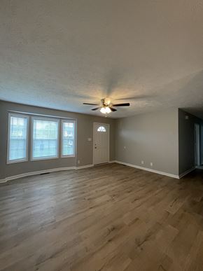 Oak Grove house for rent - an empty living room with wood floors and a ceiling fan