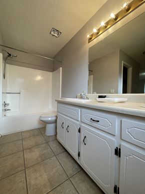 Clarksville house for rent - A bathroom with a white toilet and a white sink.