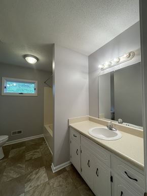 Clarksville house for rent - A bathroom with a sink, mirror, and tiled floor.