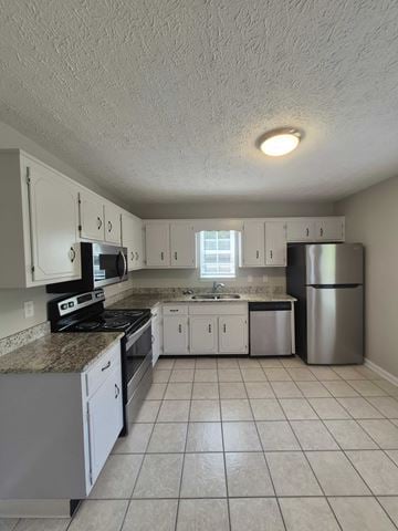 Oak Grove house for rent - A kitchen with white cabinets and a granite counter top.