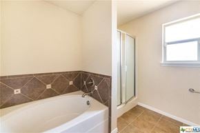 Copperas Cove house for rent - a bathroom with a tub and a shower and a window
