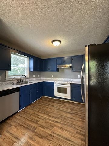 Clarksville house for rent - A kitchen with blue cabinets and a black refrigerator.