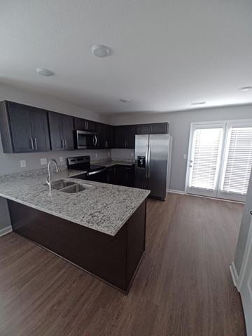 Clarksville house for rent - A kitchen with a granite countertop and wooden flooring.