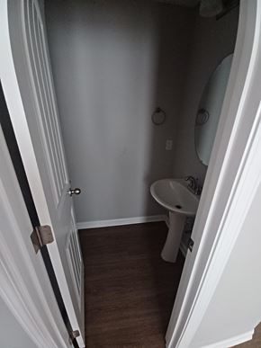 Clarksville house for rent - A white door is open to a small bathroom with a toilet and sink.