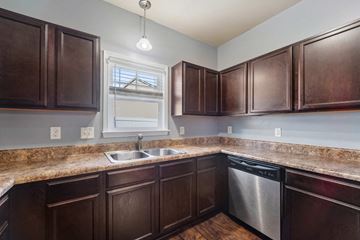 Jacksonville house for rent - A kitchen with brown cabinets and a granite countertop.