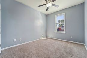 Jacksonville house for rent - A room with a ceiling fan and a window showing a view of a building outside.