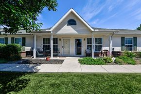 Sycamore apartment for rent - the front of a white house with a porch and lawn