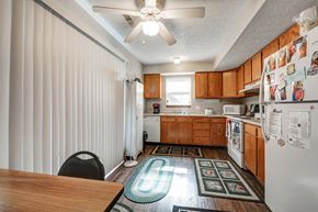 Carrollton apartment for rent - a kitchen with white appliances and wooden cabinets and a ceiling fan