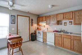Clyde apartment for rent - a kitchen with white appliances and wooden cabinets and a table