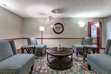 Barnesville apartment for rent - a living room with chairs and tables and a mirror