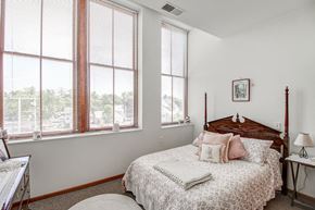 Durand apartment for rent - a bedroom with a bed and three windows