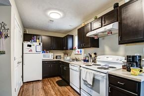 Parkersburg apartment for rent - a kitchen with white appliances and dark cabinets