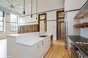 Chicago apartment for rent - a large white kitchen with a large center island and a sink