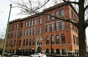 Chicago apartment for rent - a large brick building with cars parked in front of it