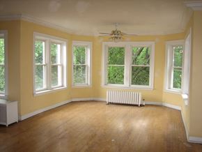 Chicago apartment for rent - an empty living room with yellow walls and a wood floor