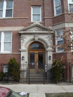 Chicago apartment for rent - the front door of a brick building with a wrought iron gate