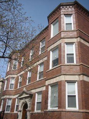 Chicago apartment for rent - a red brick building with windows and a tree
