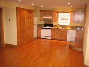 Chicago apartment for rent - an empty kitchen with wooden floors and white appliances