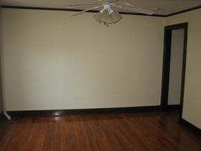 Glen Ellyn apartment for rent - an empty living room with a ceiling fan and wooden floors
