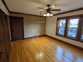 Chicago apartment for rent - an empty living room with a ceiling fan and a wood floor