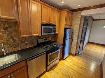 Chicago apartment for rent - a kitchen with stainless steel appliances and wooden cabinets
