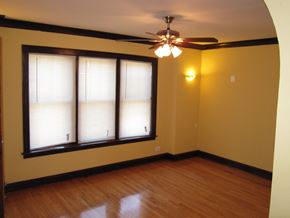 Chicago apartment for rent - an empty living room with a ceiling fan and two windows