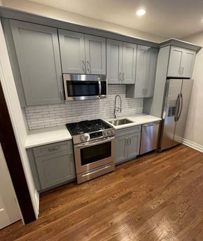 Chicago apartment for rent - a kitchen with gray cabinets and stainless steel appliances