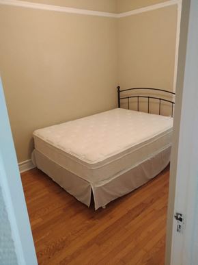 Chicago apartment for rent - a bedroom with a bed and a wooden floor
